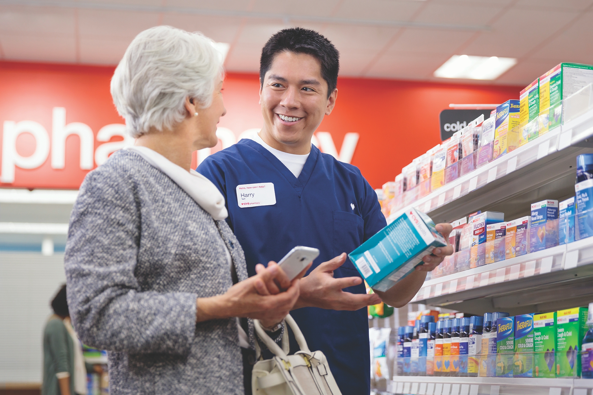 Pharmacy technician assisting customer in CVS Pharmacy